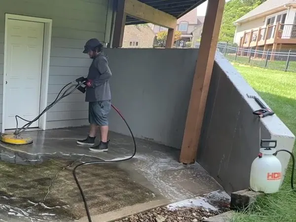 Elite Pressure Pros technician cleaning concrete with a rotary surface cleaner
